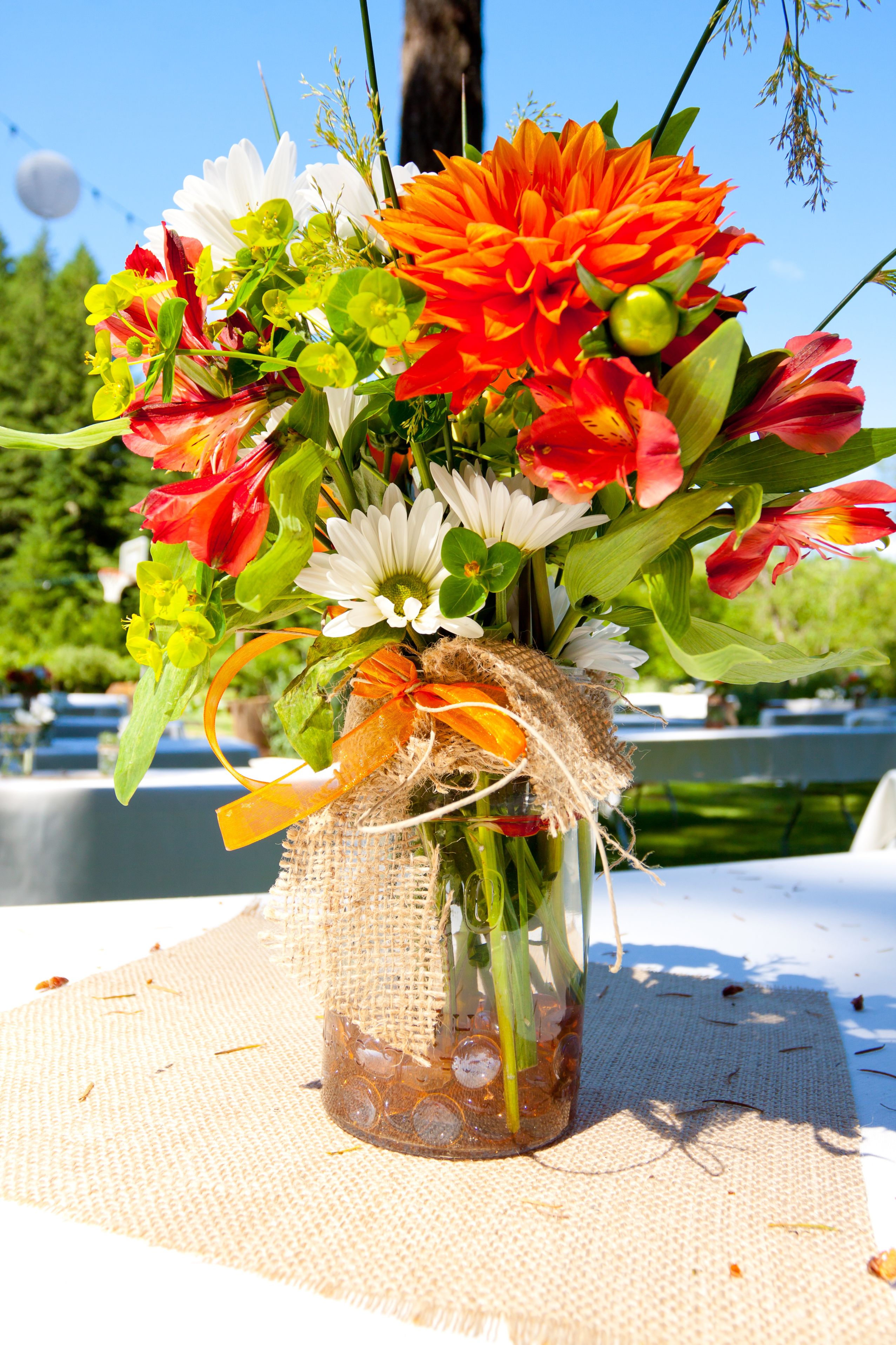 bouquet de fleurs colorées dans un bocal décoré avec jute et ruban
